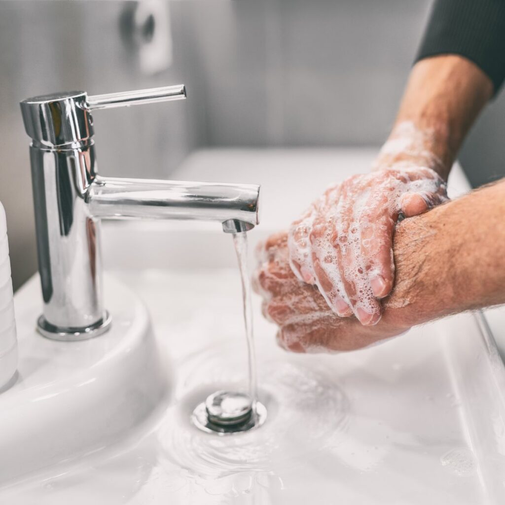 man washing his hands with soap and water