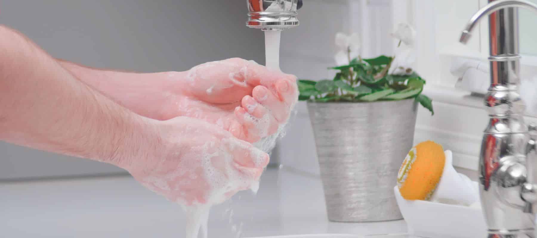 Person using soap and water to wash their hands