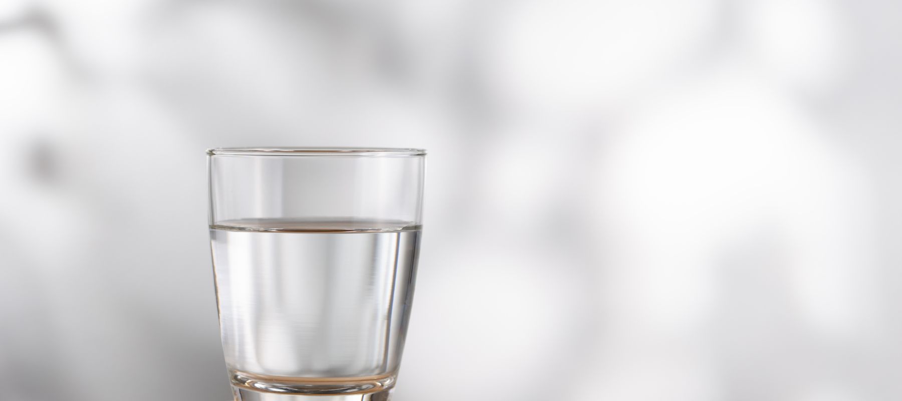 a glass of water sitting on a shelf
